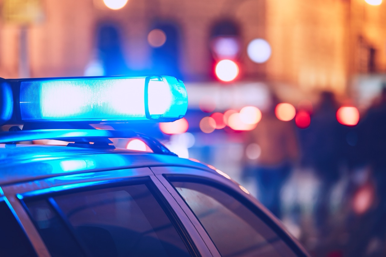 Blue emergency lights on top of a police car at night